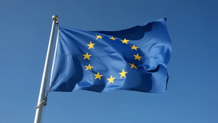 A european flag slowly waving in the wind on a bright blue sky